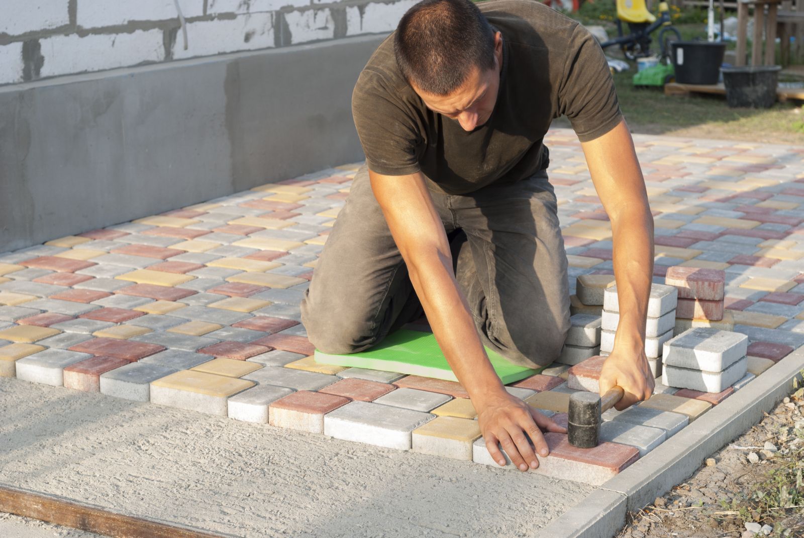 Man-legt-tegels-in-de-tuin